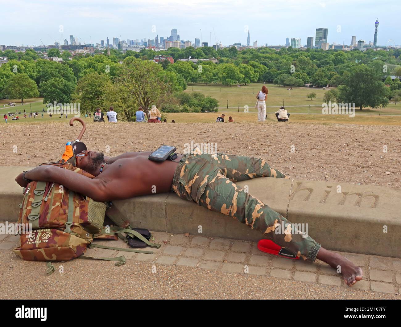 Lui, uomo che si rilassa su Primrose Hill, parco pubblico, London Borough of Camden, cima collina, Londra, Inghilterra, Regno Unito, NW1 Foto Stock