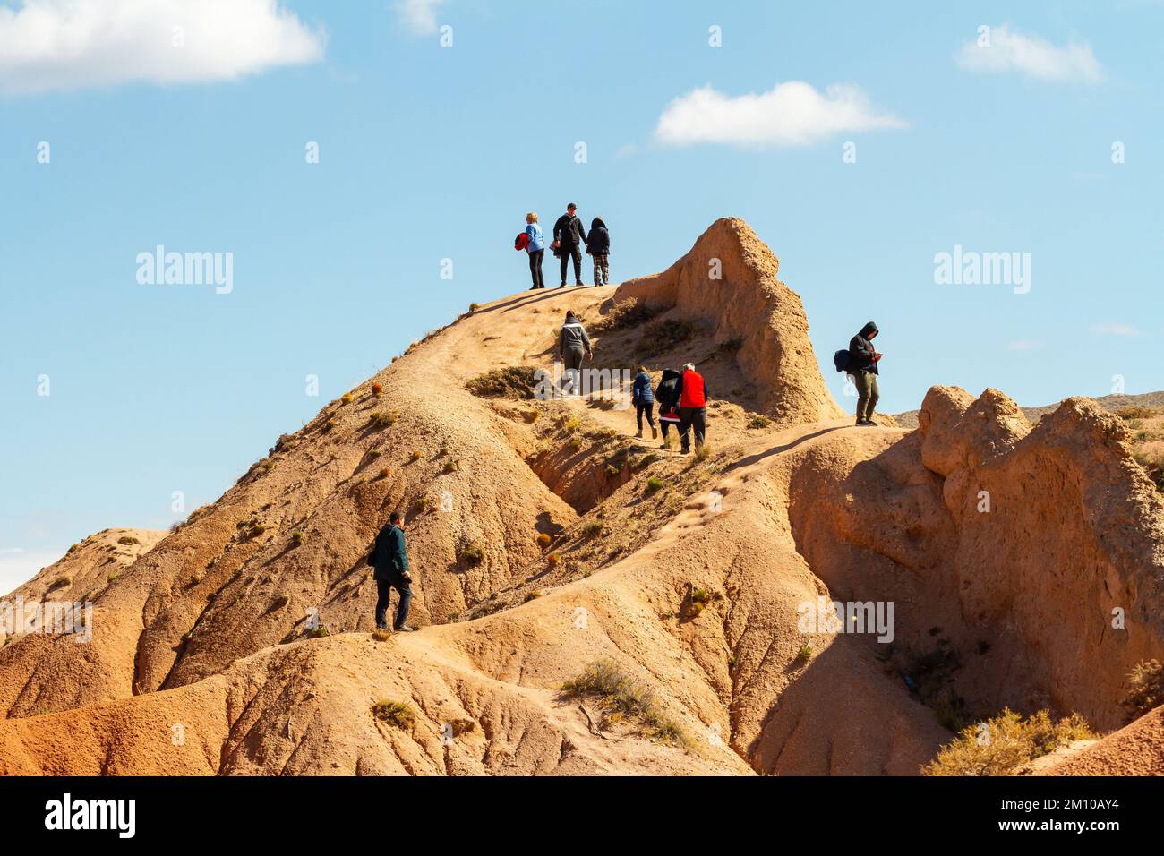 I turisti camminano intorno al canyon fiabesco o al Canyon Skazka, parco naturale di rocce colorate vicino al lago Issyk-Kul, Kirghizistan. Foto Stock