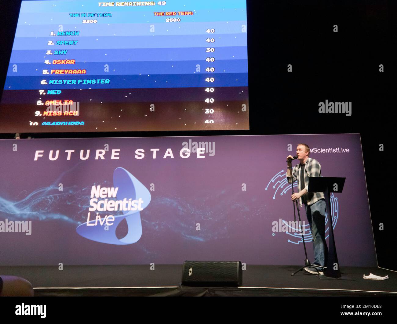 Steve McNeil assistito da Rob Sedgebeer, offre una dimostrazione dal vivo dell'evoluzione dei videogiochi, con il pubblico che partecipa, tramite i propri smartphone, al Future Stage, al New Scientist Live 2022 Foto Stock