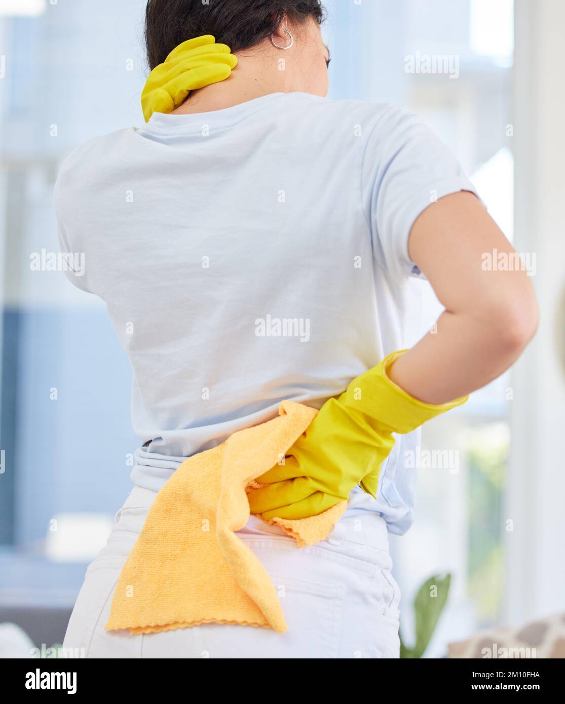 Dolore al collo, pulizia e donna con lesioni a casa dopo aver lavorato sodo. Pulizia primaverile, governante e femmina con artrite, mal di schiena o fibromialgia Foto Stock