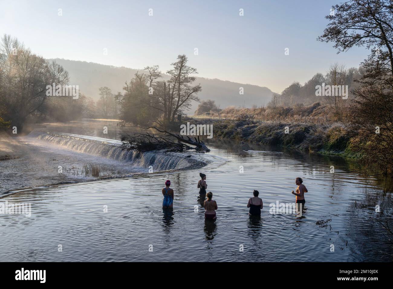 I nuotatori sfidano l'acqua nel fiume Avon a Warleigh Weir vicino a Bath nel Somerset questa mattina, mentre le temperature si tuffano nel Regno Unito. Foto Stock