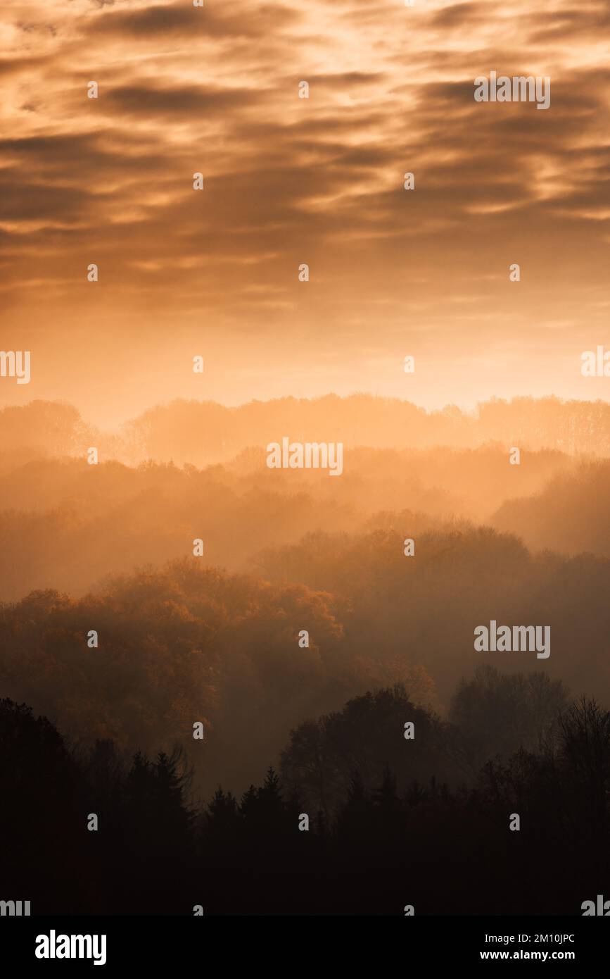 Vista aerea di una chiesa con alberi in primo piano nei toni caldi del tramonto in Germania, cielo drammatico Foto Stock