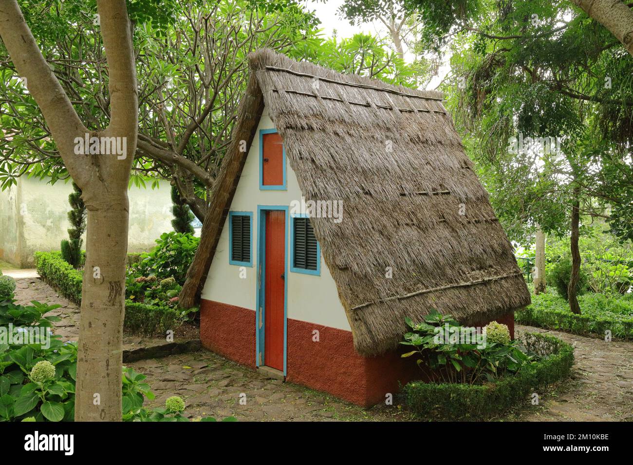 Tradizionale cottage tetto di paglia nei Giardini Botanici, Funchal, Madeira. Foto Stock