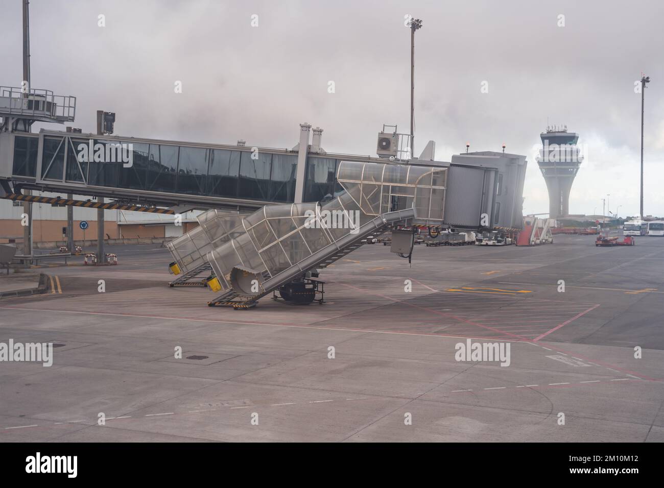 Accesso alla passerella per l'aeromobile e la sua torre di controllo in una giornata grigia e scura. Foto Stock