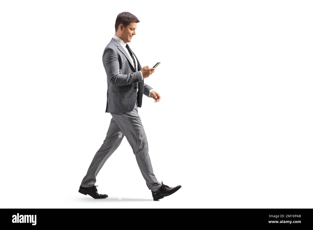 Immagine a tutto profilo di un professionista che utilizza uno smartphone e che cammina isolato su sfondo bianco Foto Stock