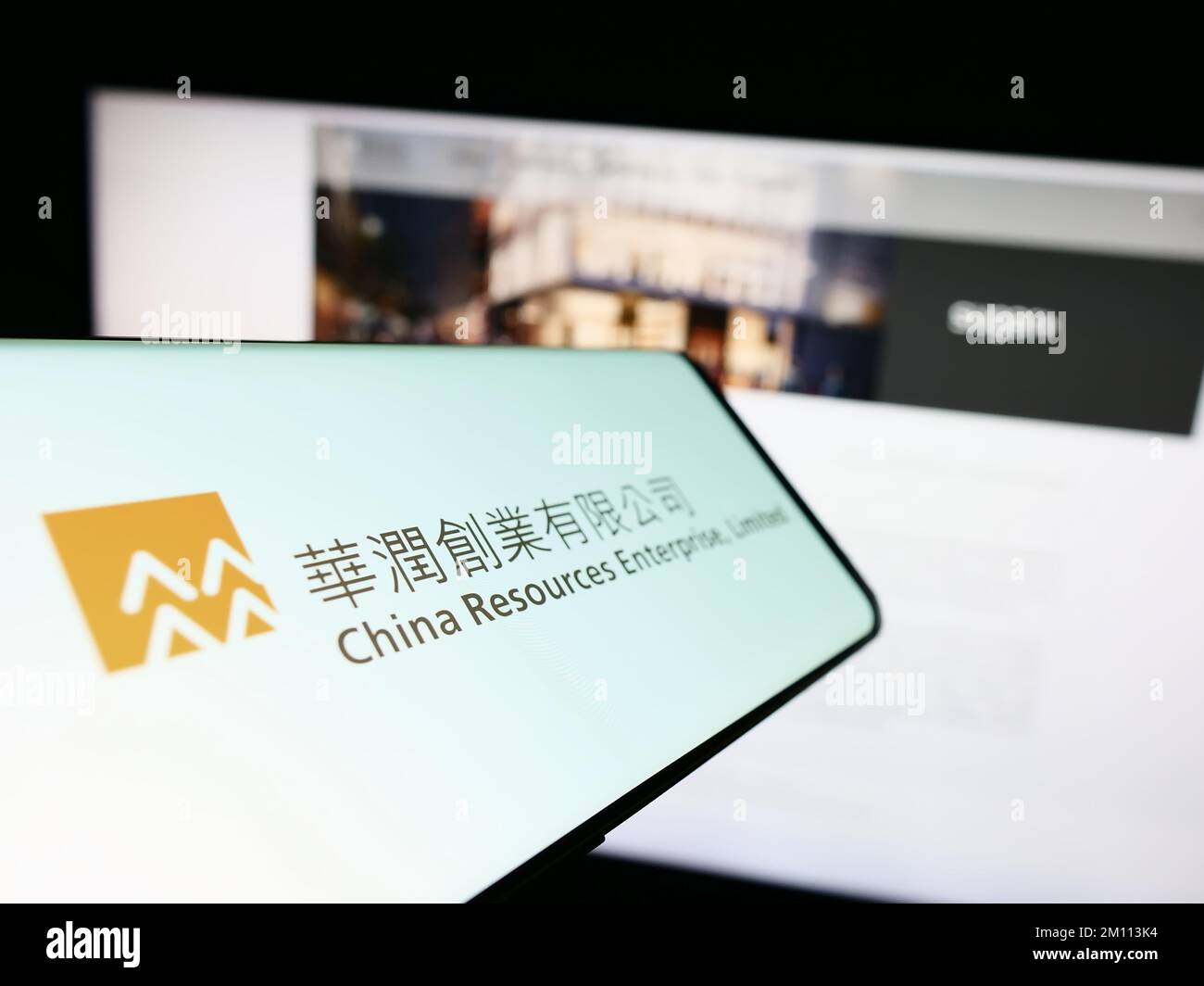 Telefono cellulare con il logo della società China Resources Enterprise Limited sullo schermo davanti al sito Web. Messa a fuoco al centro a sinistra del display del telefono. Foto Stock