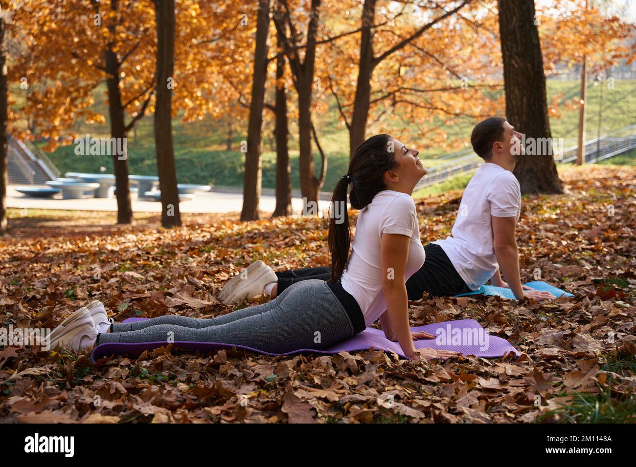 Una studentessa snella e la sua amica stanno facendo yoga sui karimat Foto Stock