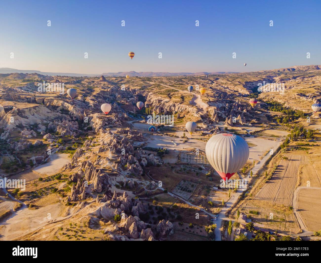 Coloratissime mongolfiere che volano nella valle dei camini delle fate a Nevsehir, Goreme, Cappadocia Turchia. Spettacolare vista panoramica del drone Foto Stock
