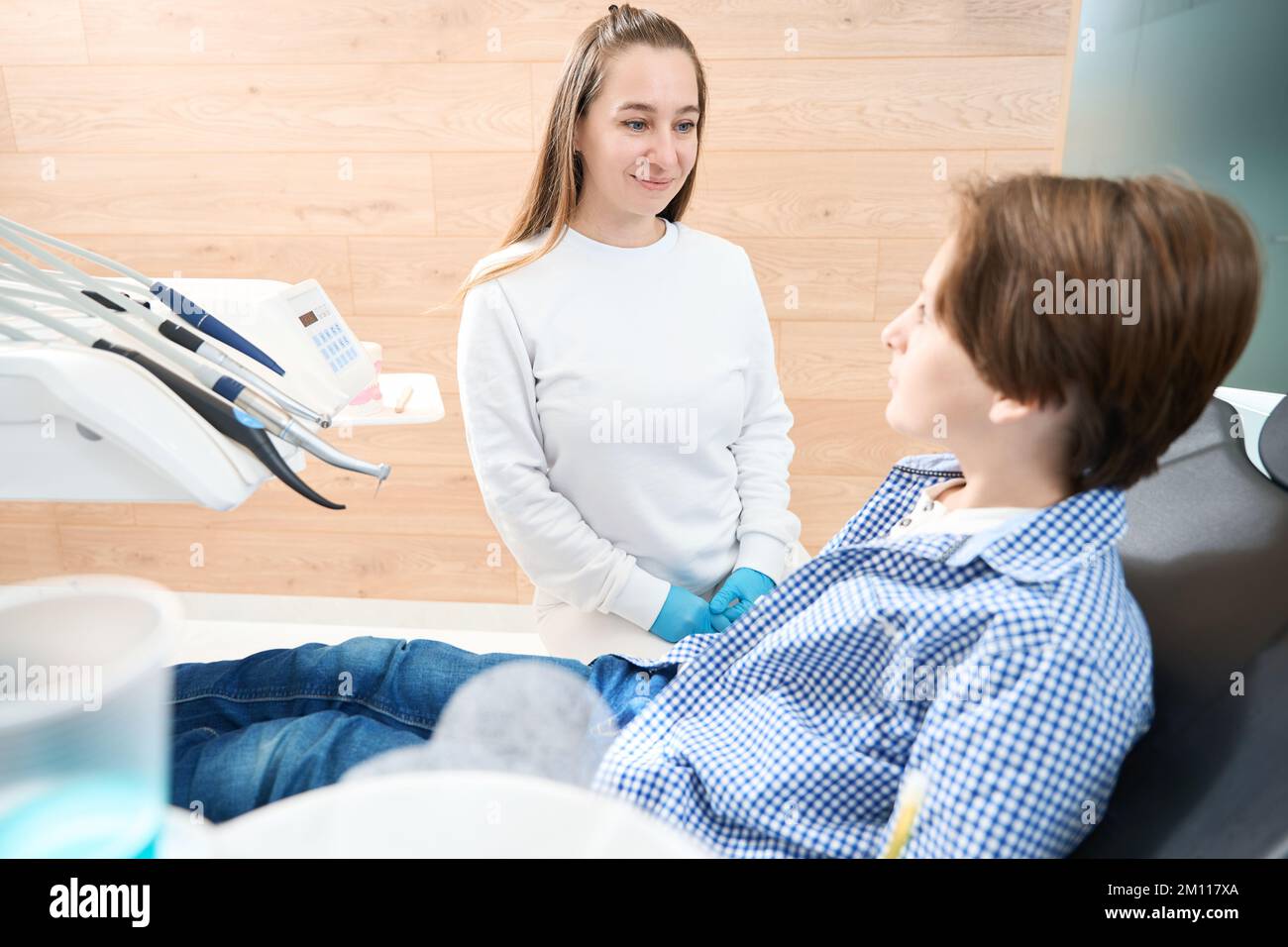 Donna dentista conduce la ricezione di un ragazzo adolescente Foto Stock