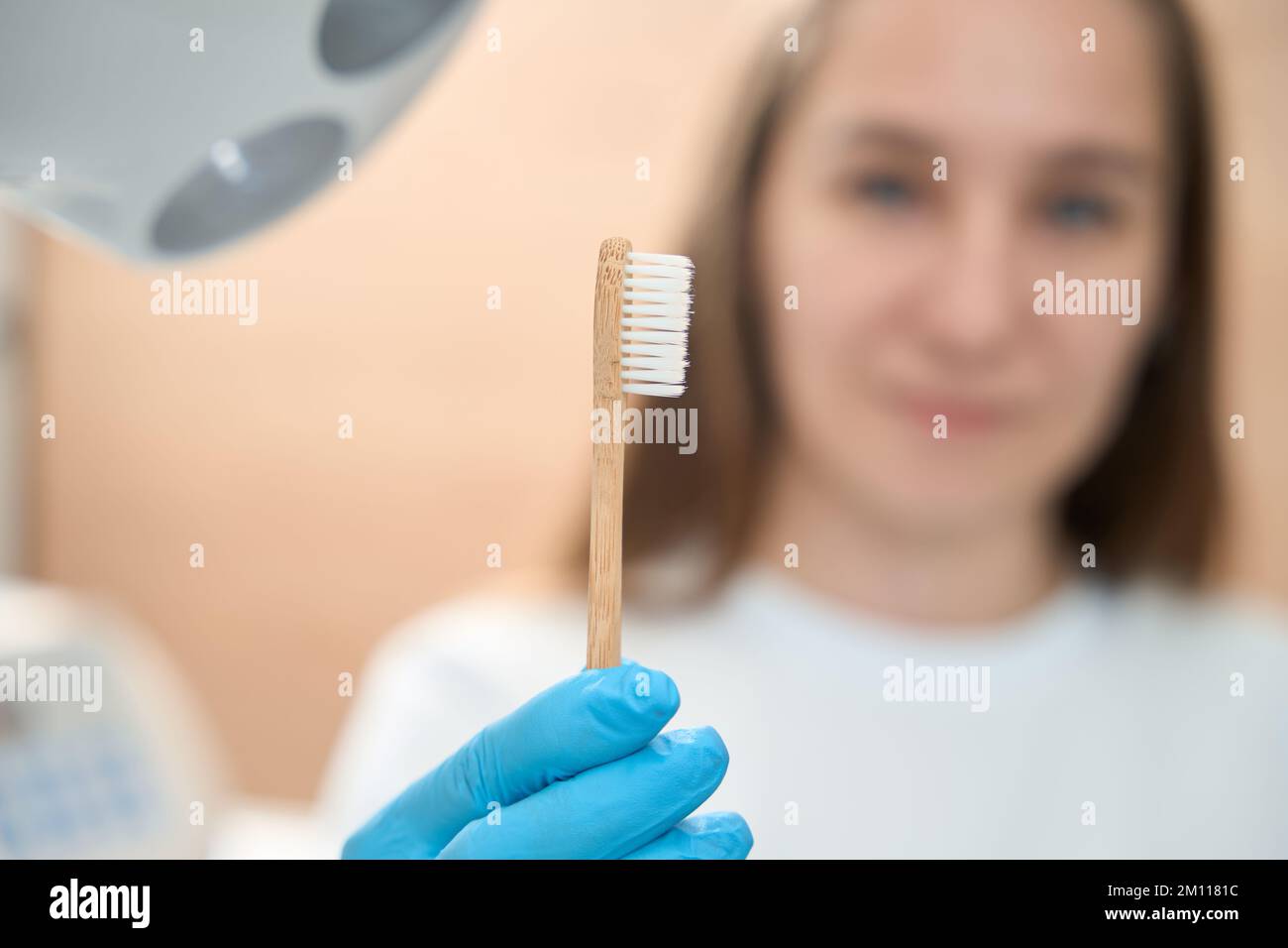Il dentista donna in studio dentale tiene lo spazzolino nelle sue mani Foto Stock