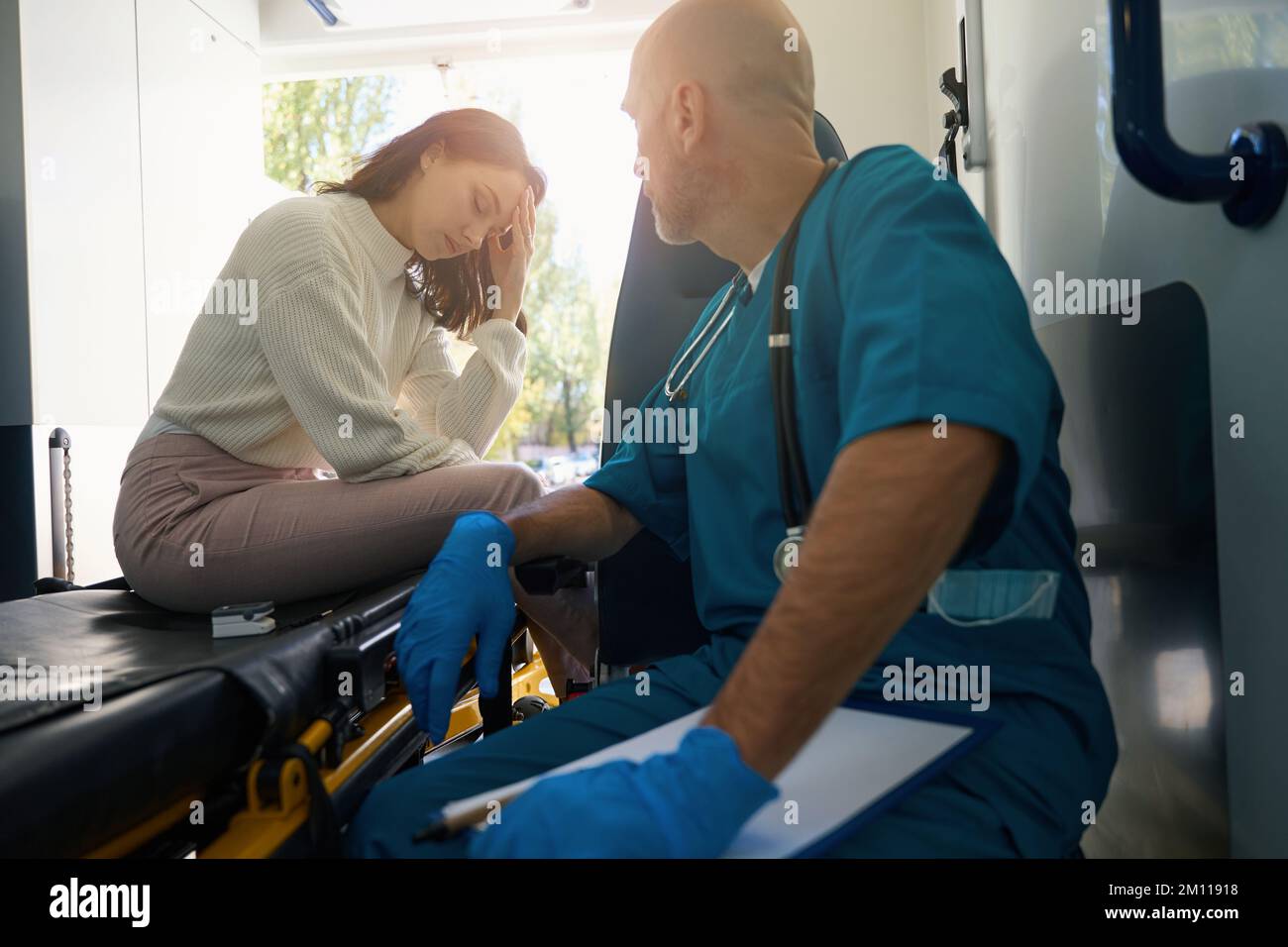 Medico e paziente sono seduti in un'ambulanza mobile Foto Stock