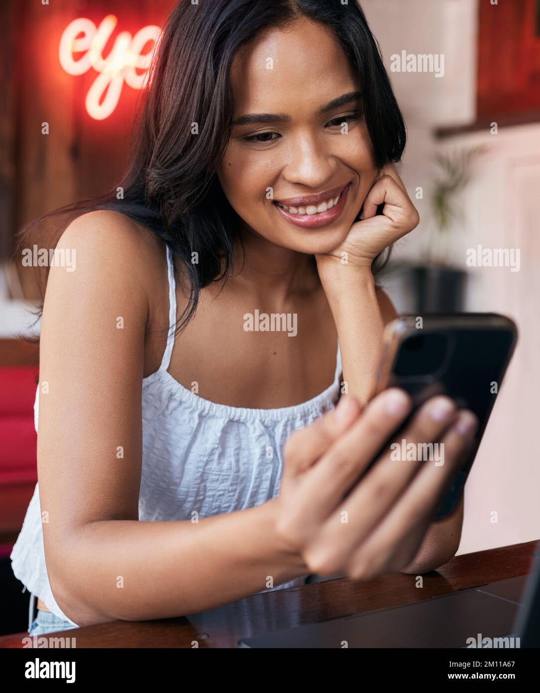 Telefono, social media e comunicazione con una donna nera in un bar o internet cafe per rilassarsi da soli. Contatto, cellulare e social network con un Foto Stock