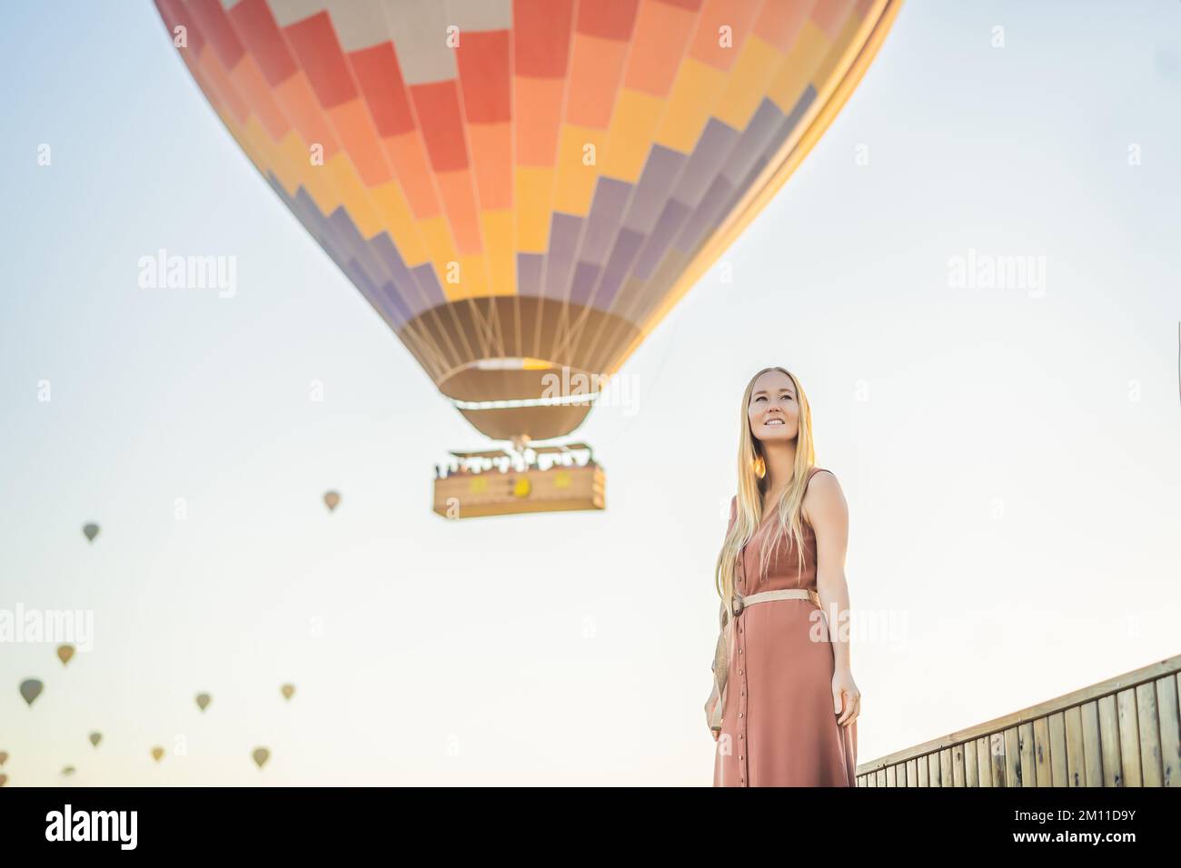 Donna turistica che guarda mongolfiere in Cappadocia, Turchia. Buon viaggio in Turchia concetto. Donna in cima a una montagna che gode di una vista meravigliosa Foto Stock