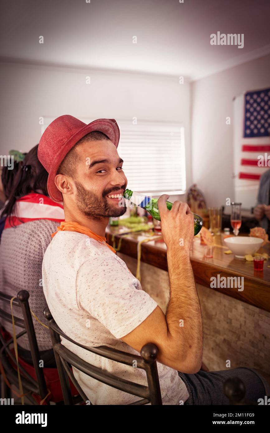 Ritratto, uomo e birra a casa festa, camera e dormitorio universitario negli Stati Uniti per la celebrazione di nuovo anno, divertimento e libertà. Ragazzo felice, bevendo bottiglia di alcool Foto Stock