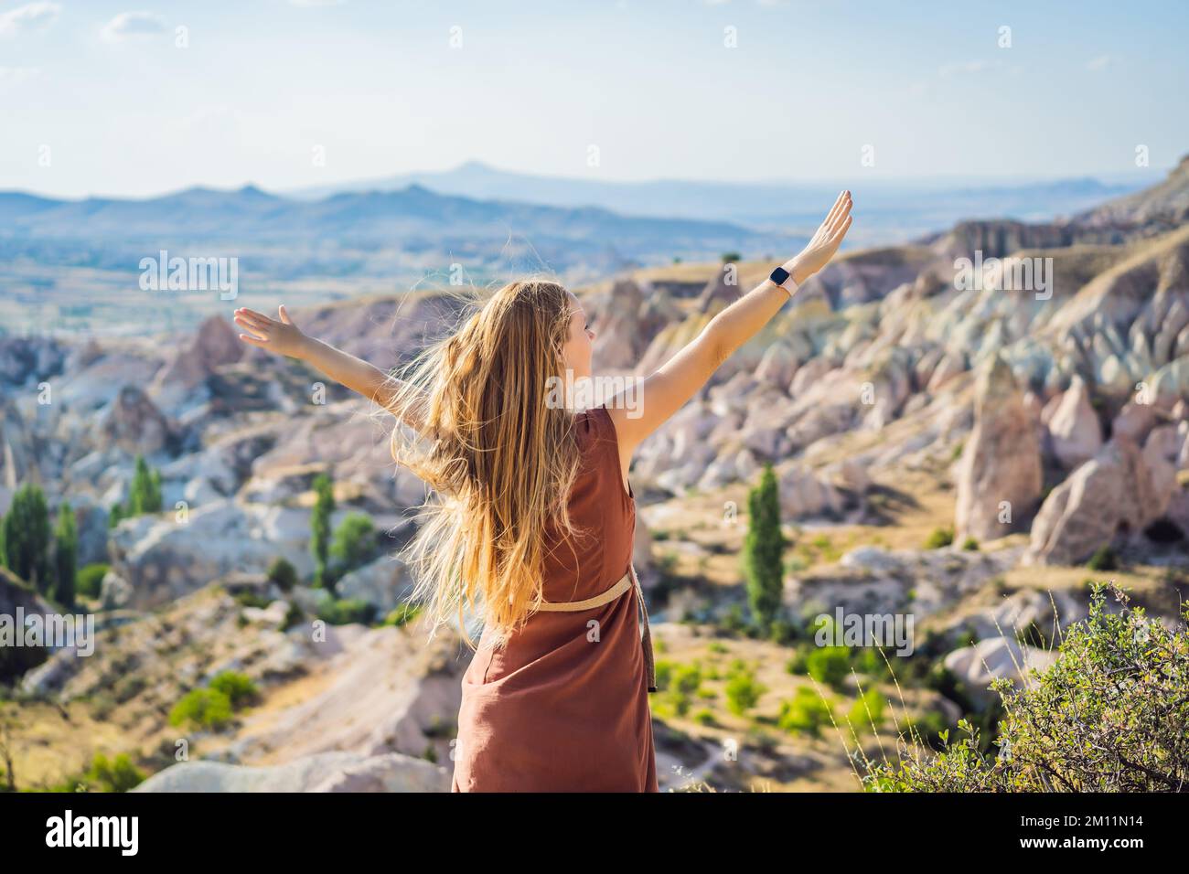 Giovane donna che esplora la valle con formazioni rocciose e grotte delle fate vicino a Goreme in Cappadocia Turchia Foto Stock