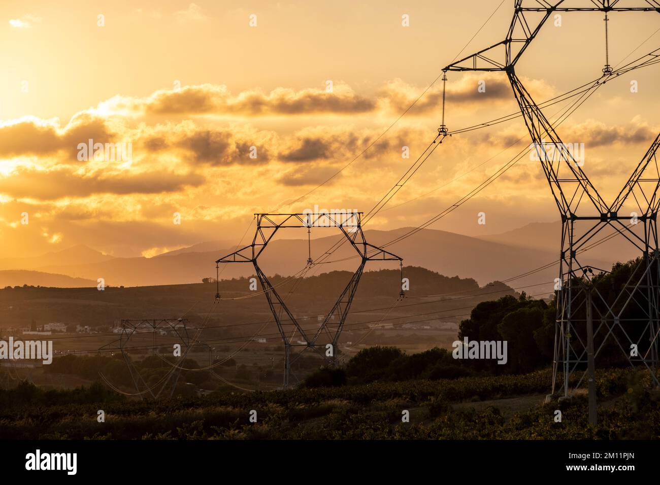 Cavi ad alta tensione con il cielo al tramonto sullo sfondo Foto Stock
