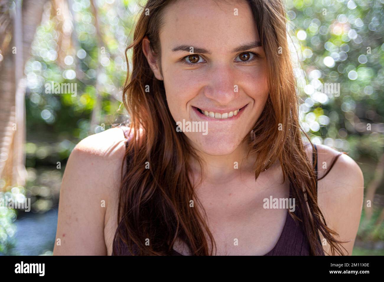 Giovane donna in posa di fronte a uno sfondo naturale Foto Stock