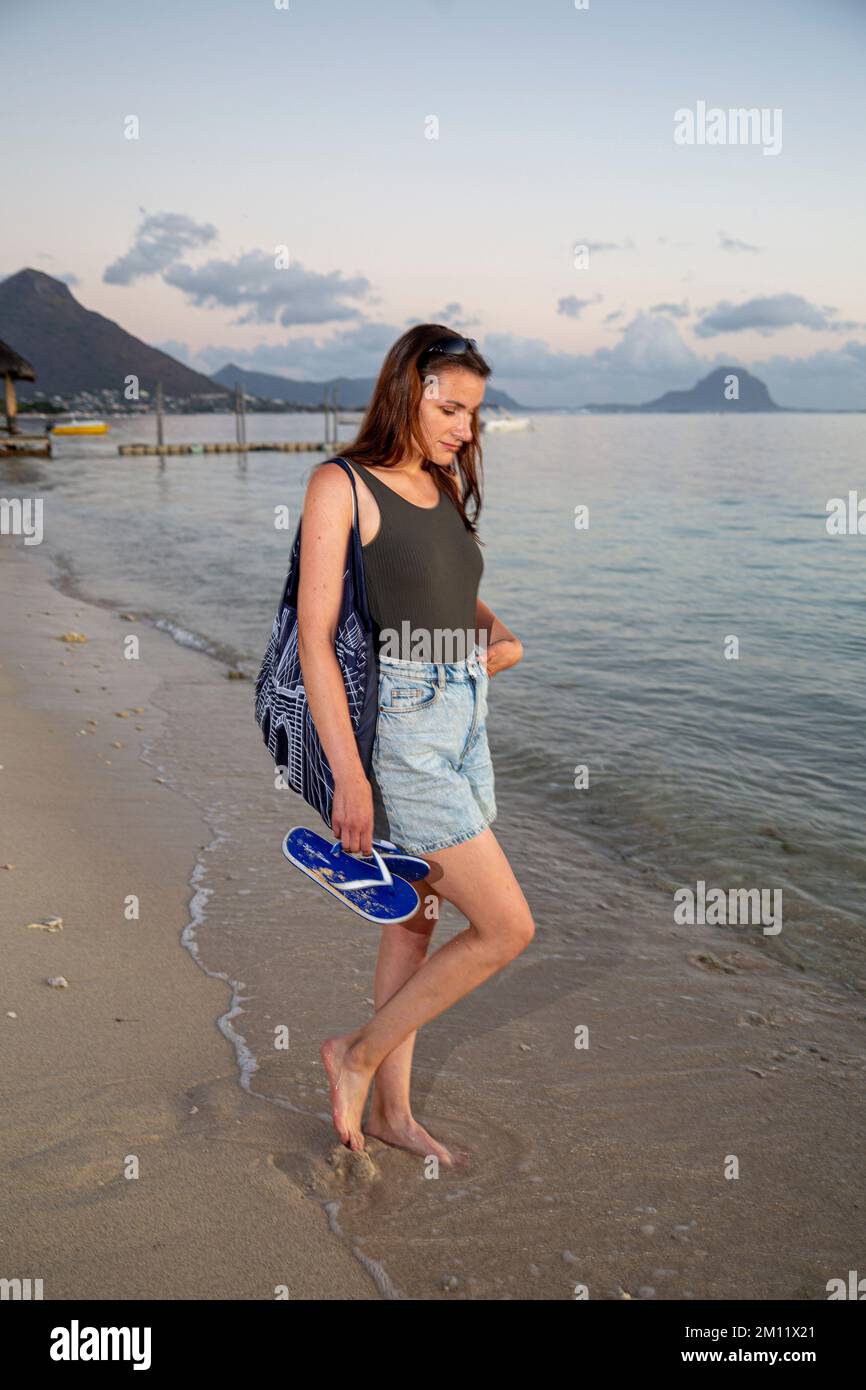 Giovane modella femminile durante il tramonto sulla spiaggia di flic en flac a Mauritius Island, Africa Foto Stock