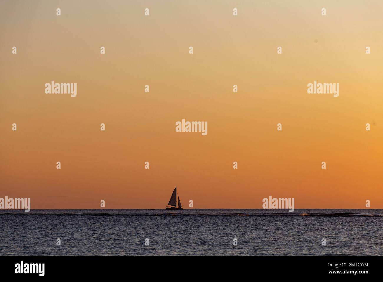 Una nave solitaria all'orizzonte durante il tramonto a Mauritius Island, Africa - copyspace Foto Stock