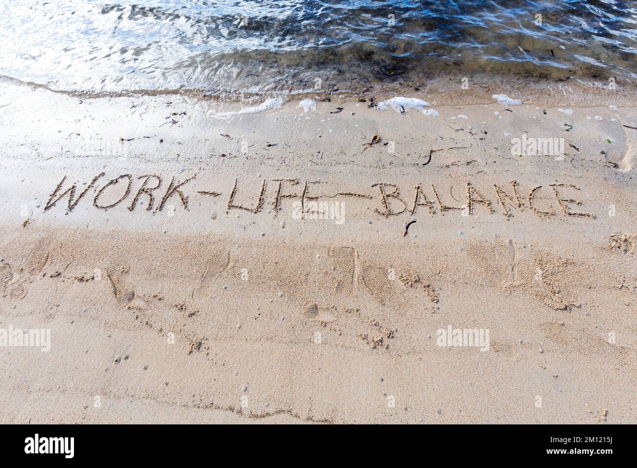 Lavoro-vita-equilibrio - come un messaggio scritto con un dito nella sabbia su una spiaggia con le onde e l'oceano blu a Mauritius Island, Africa, vista dall'alto, nessuno Foto Stock
