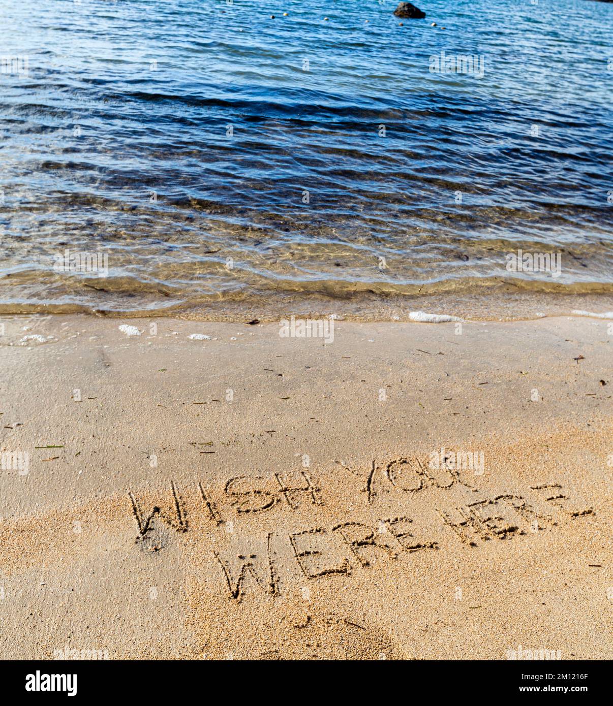 WISH YOU ARE HERE messaggio scritto con un dito nella sabbia su una spiaggia con onde e blu oceano a Mauritius Island, Africa, vista dall'alto, nessuno Foto Stock