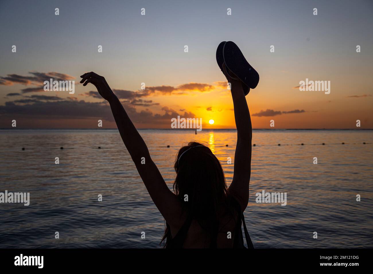 Una silhouette di una giovane modella femminile durante il tramonto sulla spiaggia di flic en flac a Mauritius Island, Africa Foto Stock