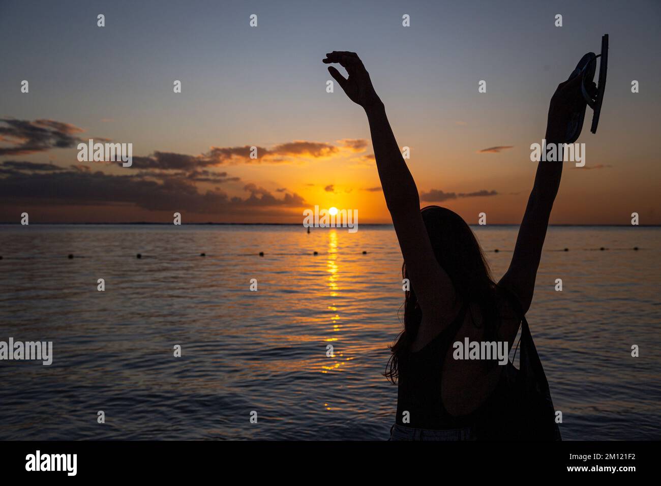 Una silhouette di una giovane modella femminile durante il tramonto sulla spiaggia di flic en flac a Mauritius Island, Africa Foto Stock