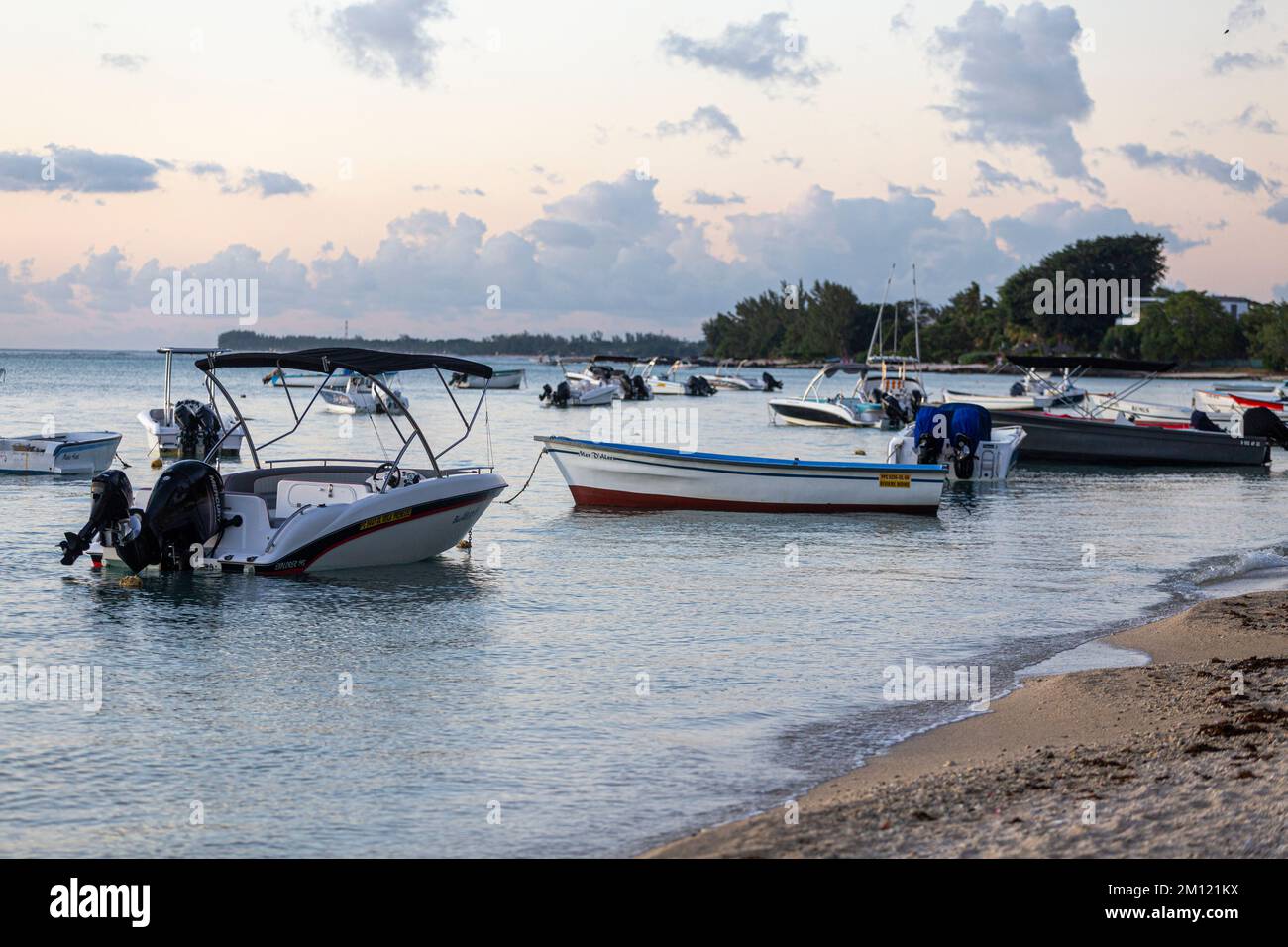 Piccole barche sulla spiaggia sulla costa occidentale dell'isola di Mauritius con cielo nuvoloso Foto Stock