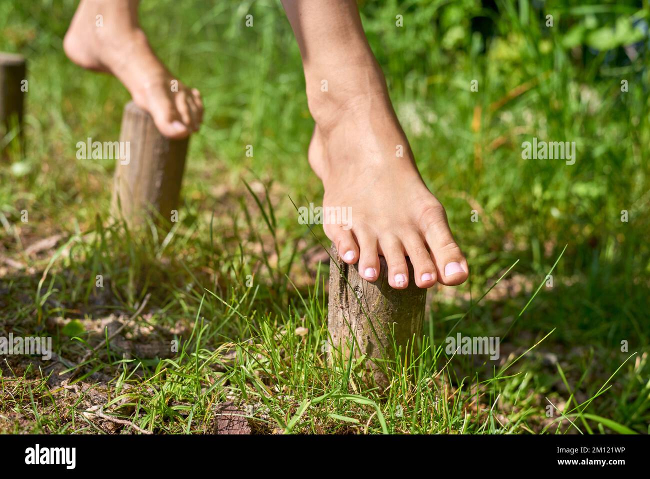 Camminare a piedi nudi - piedi equilibrando su pioli di legno, primo piano Foto Stock