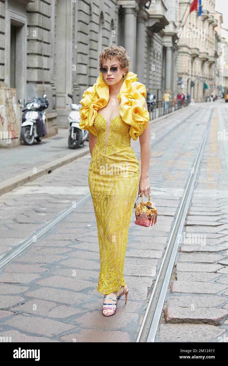 MILANO, ITALIA - 21 SETTEMBRE 2022: Donna con abito giallo con collo in raso prima della sfilata di moda Calcaterra, Milano Fashion Week Street Style Foto Stock