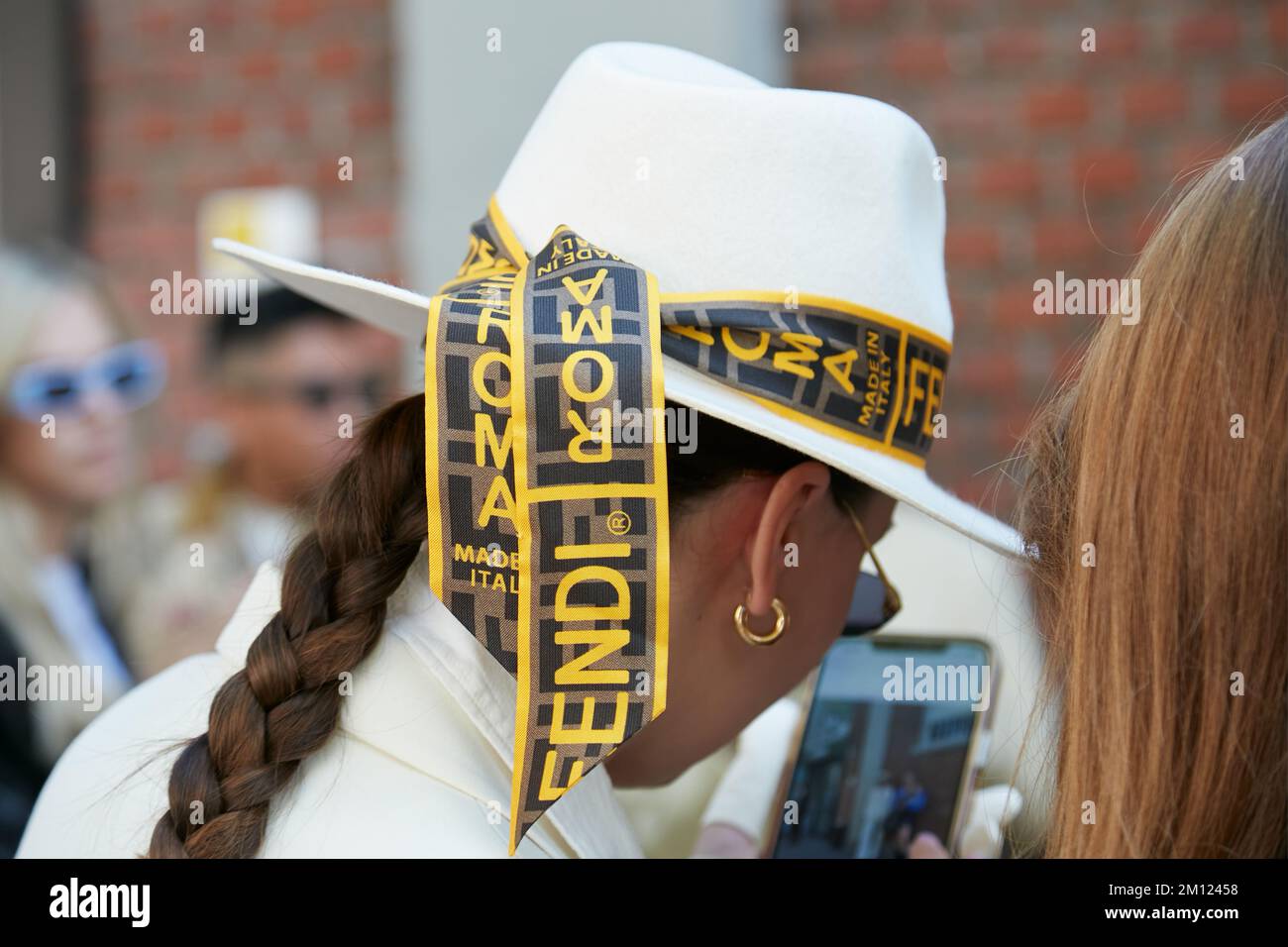 MILANO, ITALIA - 21 SETTEMBRE 2022: Donna con cappello Fendi bianco e banda con logo prima della sfilata Fendi, Milano Fashion Week Street Style Foto Stock
