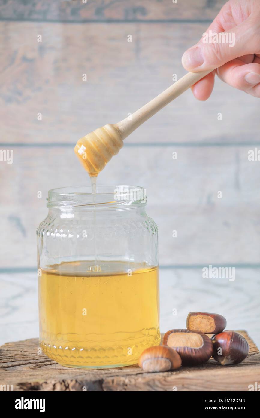 vasetto di miele d'api con cucchiaia di miele su tavola di legno antico Foto Stock