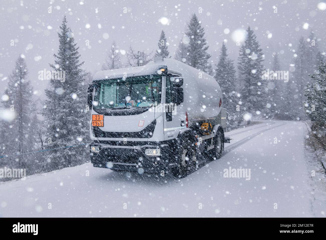 Autocisterna GPL su una strada di montagna durante una nevicata Foto Stock