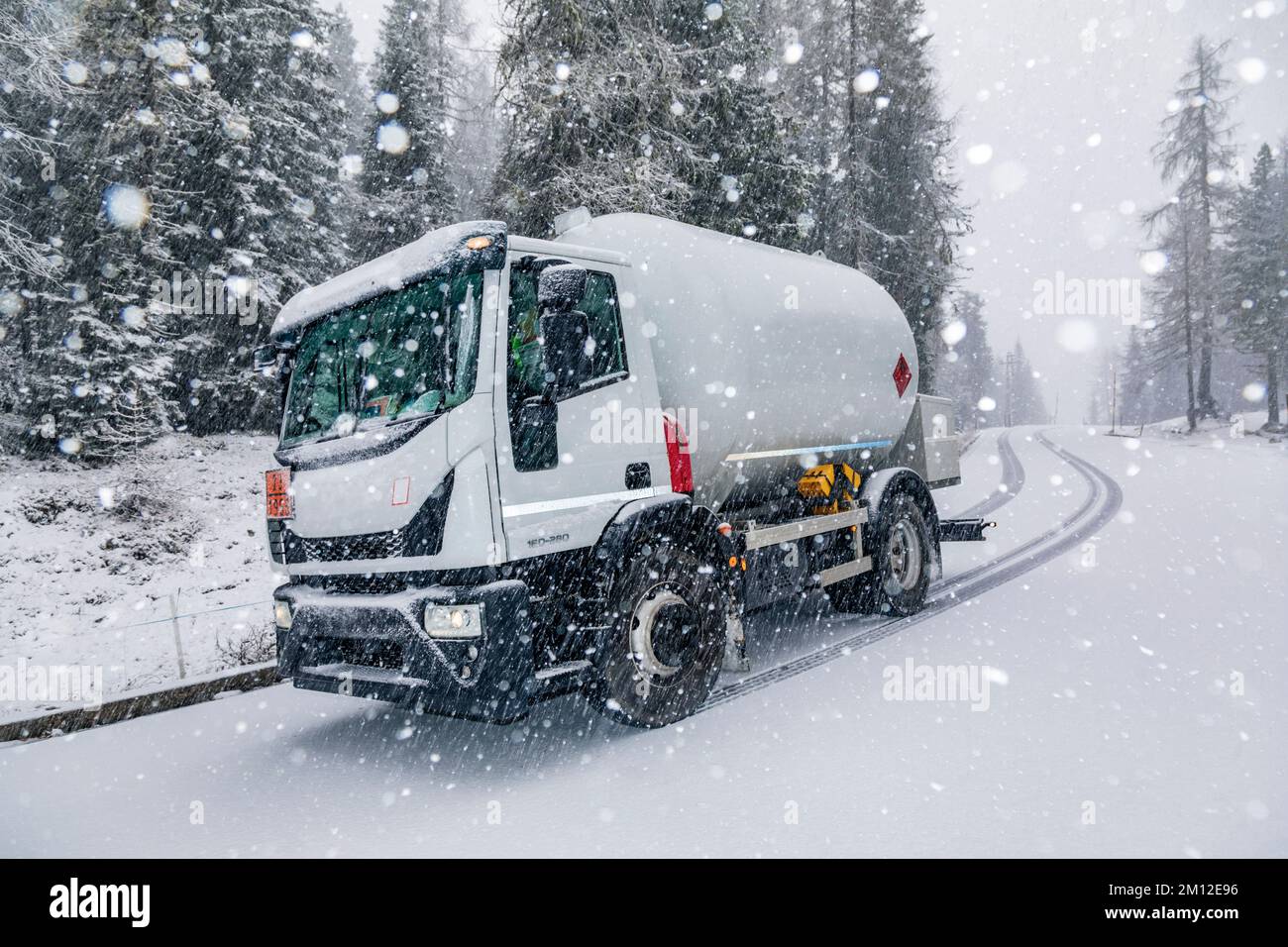 Autocisterna GPL su una strada di montagna durante una nevicata Foto Stock