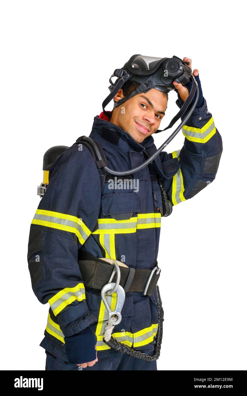 Pompiere in uniforme e con respiratore d'aria toglie la maschera protettiva Foto Stock