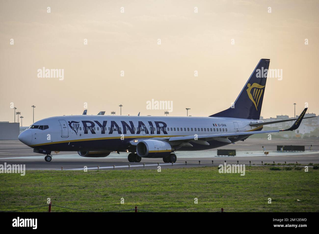 Una vista laterale dell'aereo Ryanair al tramonto all'Aeroporto di Humberto Delgado Foto Stock