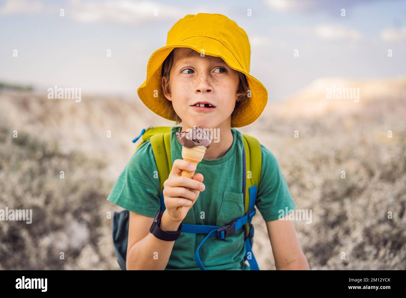 Ragazzo turistico che mangia gelato turco mentre esplori la valle con formazioni rocciose e grotte delle fate vicino a Goreme in Cappadocia Turchia Foto Stock