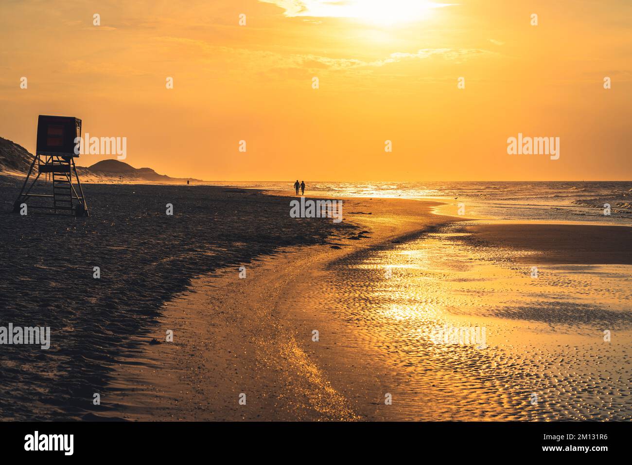 Atmosfera serale sulla spiaggia del Mare del Nord con la bassa marea, in lontananza due persone si sono stagliate Foto Stock