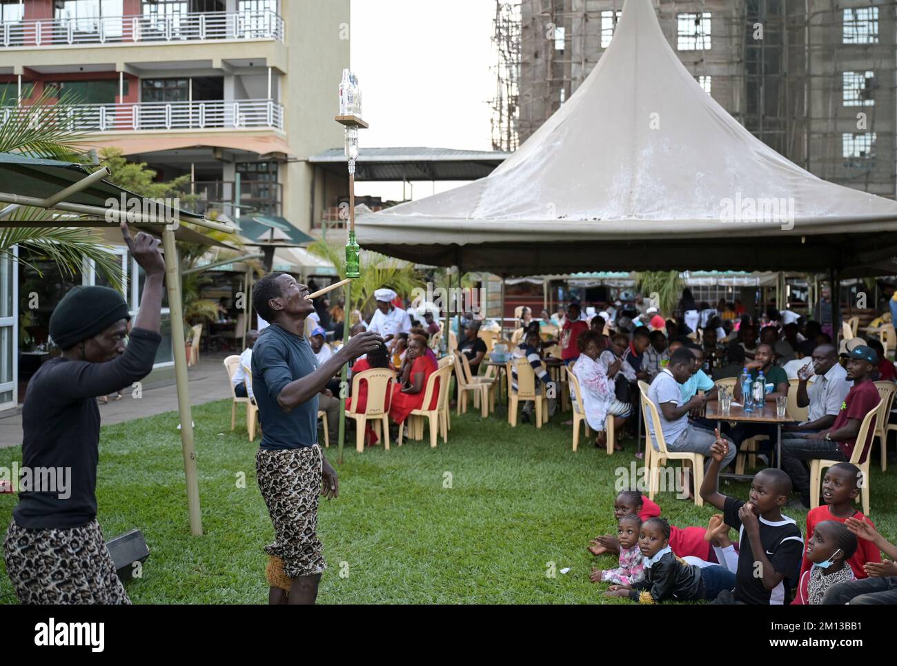 KENYA, Nairobi, classe media in birreria all'aperto, spettacolo acrobatico / KENIA, Nairobi, Mittelklasse im Biergarten, akrobatische Vorführung zur Unterhaltung der Gäste Foto Stock