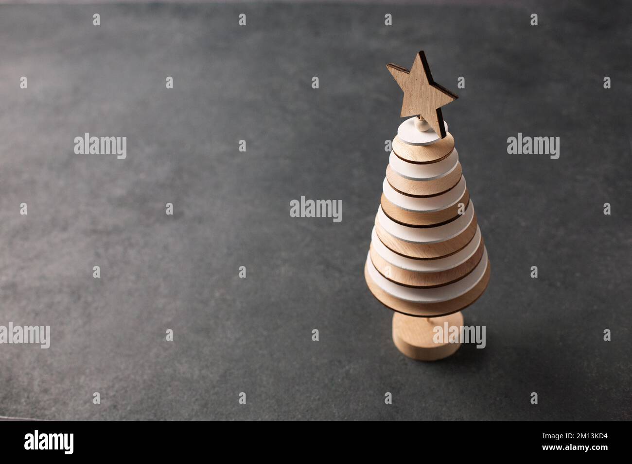 Albero di Natale creativo fatto da cerchi di legno su fondo scuro Foto Stock