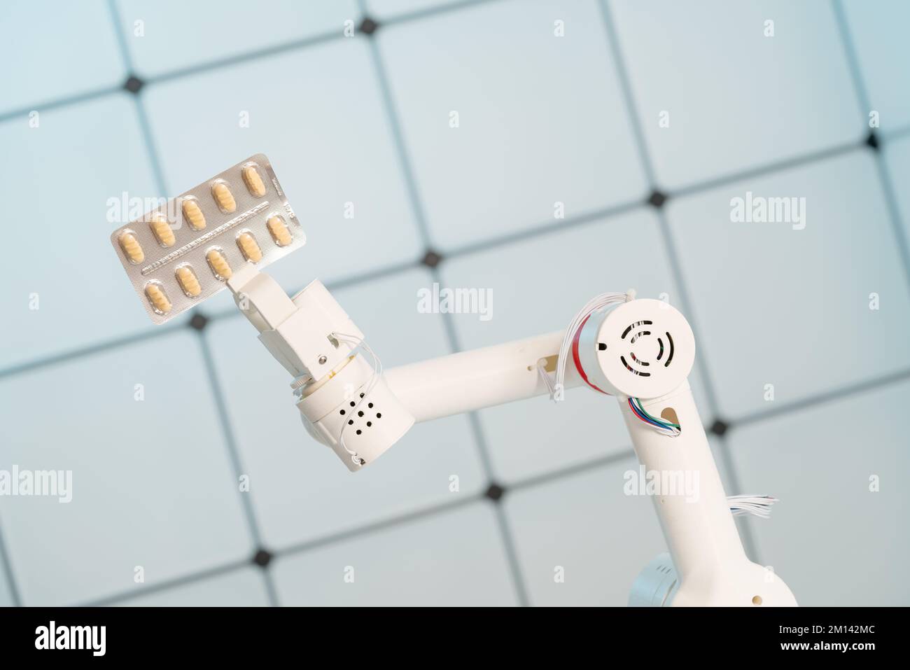 Braccio robotico contenente una confezione blister di compresse Foto Stock