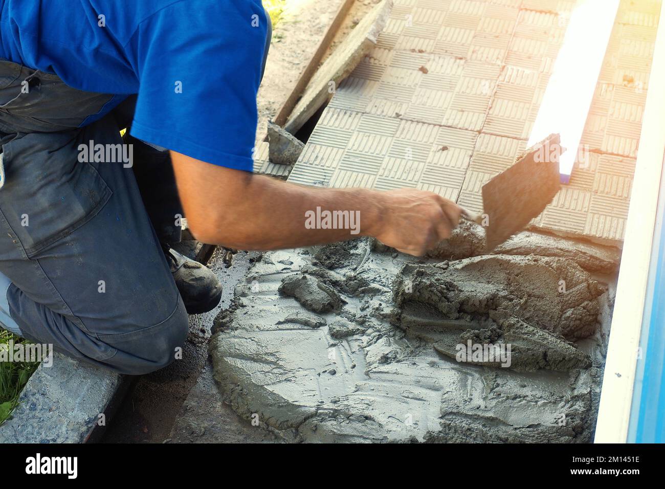 Muratore al lavoro con cazzuola e cemento Foto stock - Alamy