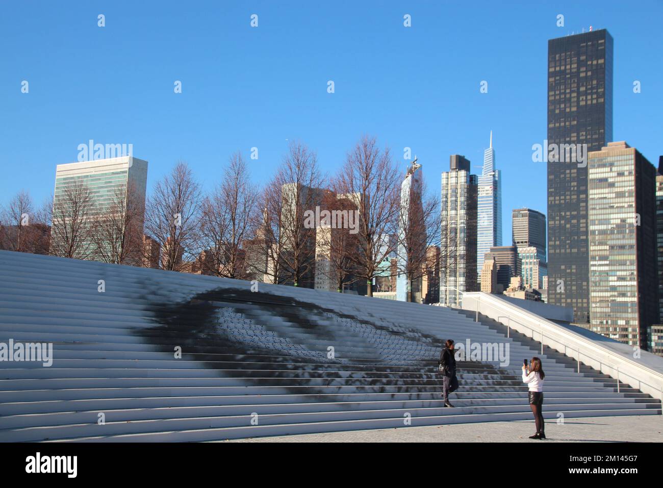 New York, Stati Uniti. 09th Dec, 2022. Visitatori di fronte al lavoro 'offerto Eye' dell'artista Shirin Neshat, con la sede delle Nazioni Unite sullo sfondo. (To dpa 'Eye on un: Art for Iran protesta a New York') Credit: Christina Horsten/dpa/Alamy Live News Foto Stock