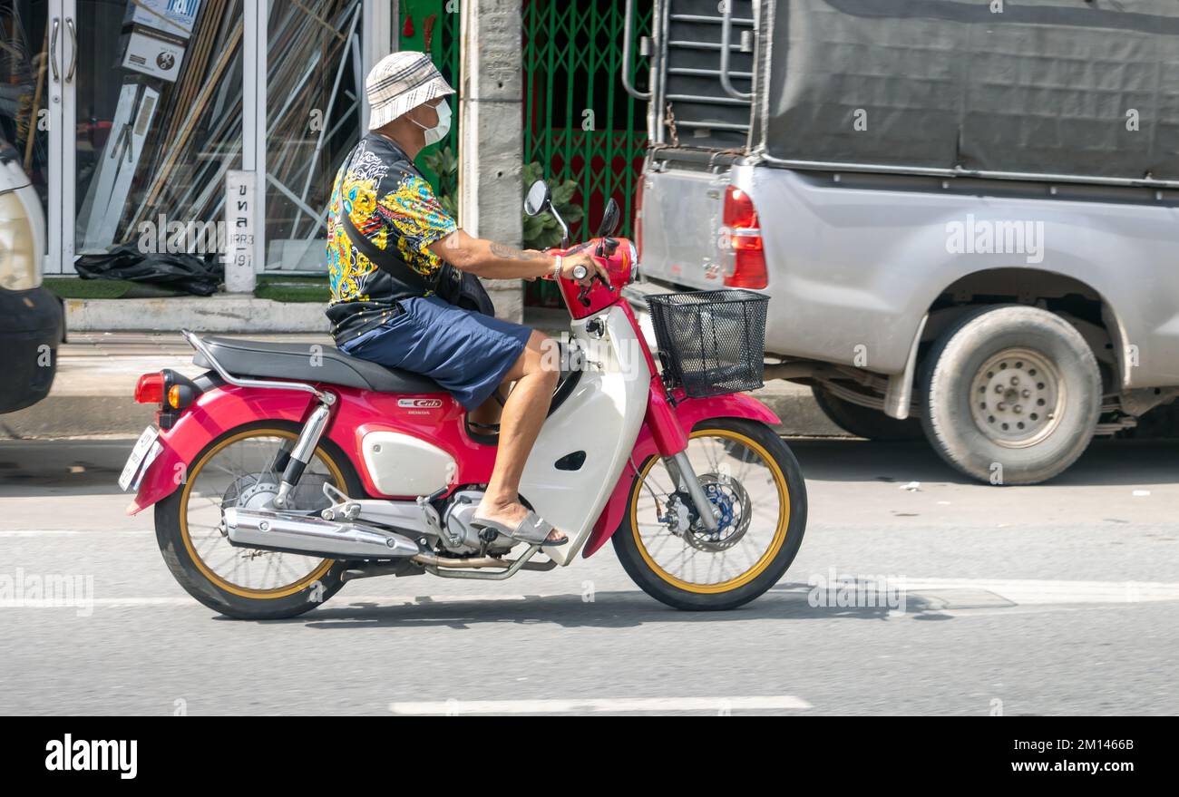 SAMUT PRAKAN, THAILANDIA, DEC 06 2022, Un uomo guida una moto lungo la strada Foto Stock