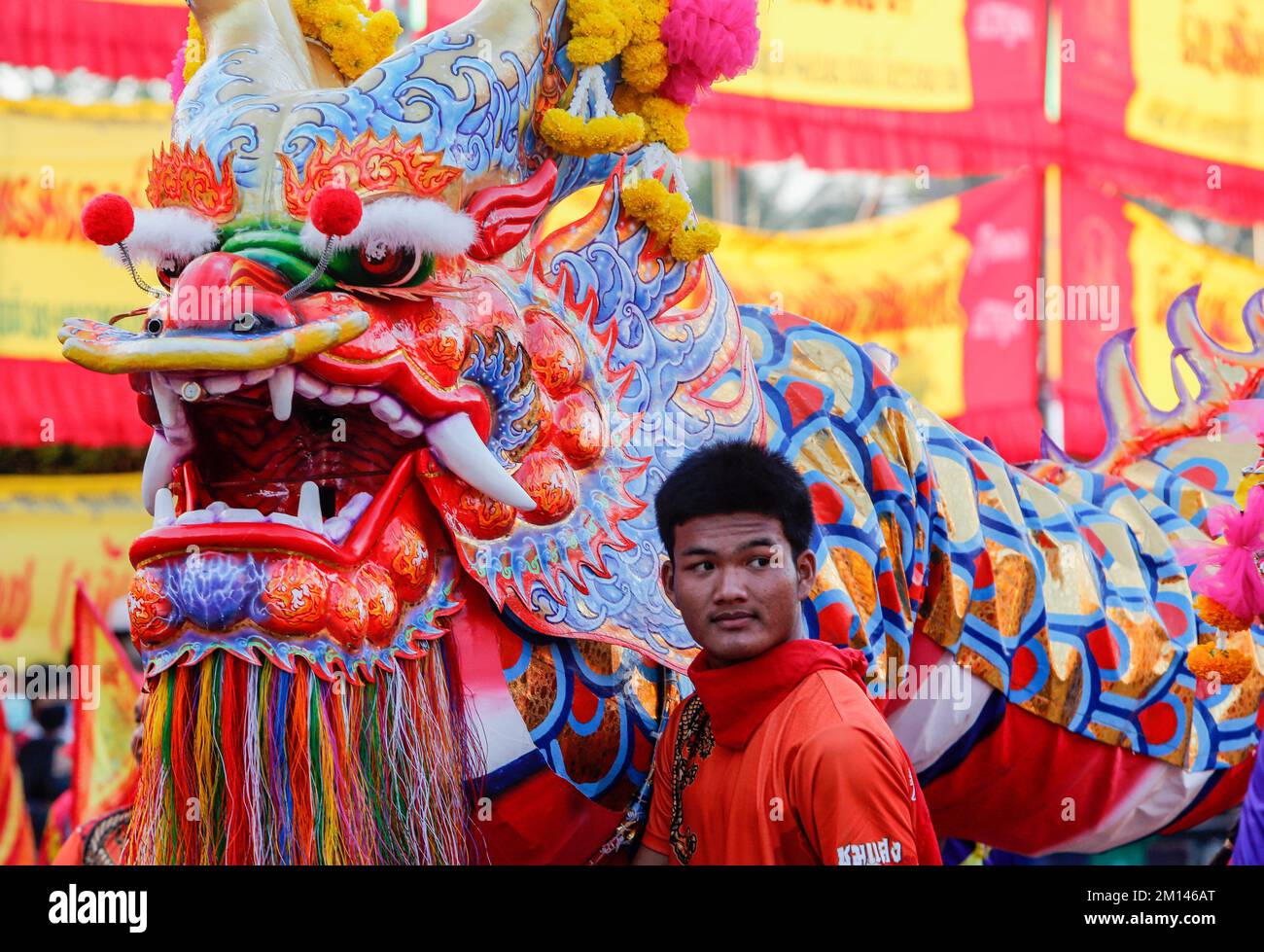 Bangkok, Thailandia. 10th Dec, 2022. Un uomo si trova accanto a una statua di un drago durante il festival Chao Por-Goddess nel quartiere di Chum Sang, Bangkok. La grande danza del Monte Liang Shan, è una danza tradizionale cinese che combina musica, danza e arti marziali eseguite da 108 ballerini che dipingevano i loro volti in diversi personaggi basati sulla storia del gregge cinese. Il famoso festival annuale è stato fondato per la prima volta nel 1947 per rispettare il Santuario di Chao Por-Goddess. Lo spettacolo consiste in una processione di attori sfilati intorno al distretto di Chum Sang. Provincia di Nakhon Sawan, acrobazie e arti marziali pe Foto Stock