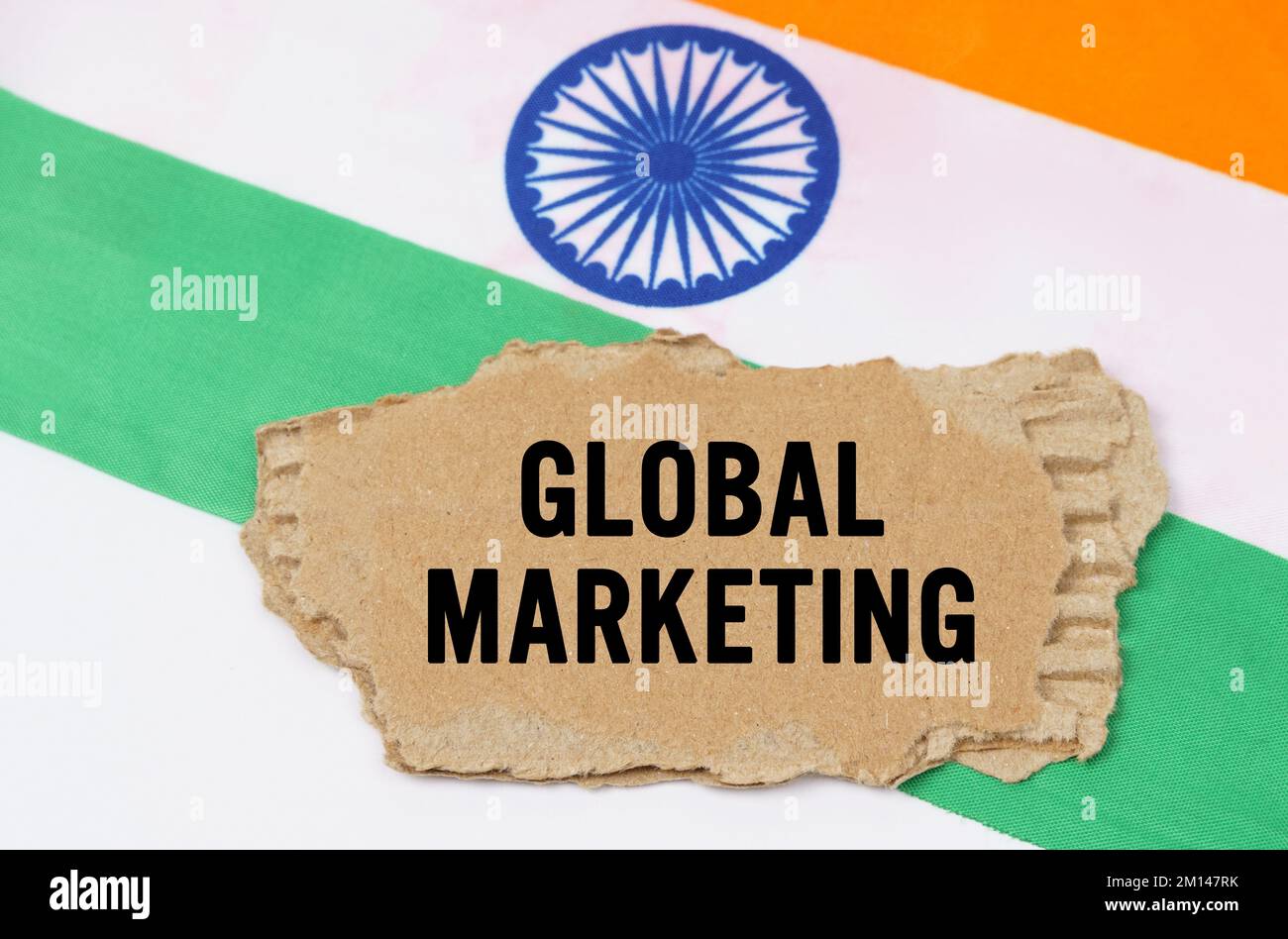 Concetto di business e finanza. La bandiera indiana ha una scatola di cartone con l'iscrizione - MARKETING GLOBALE Foto Stock
