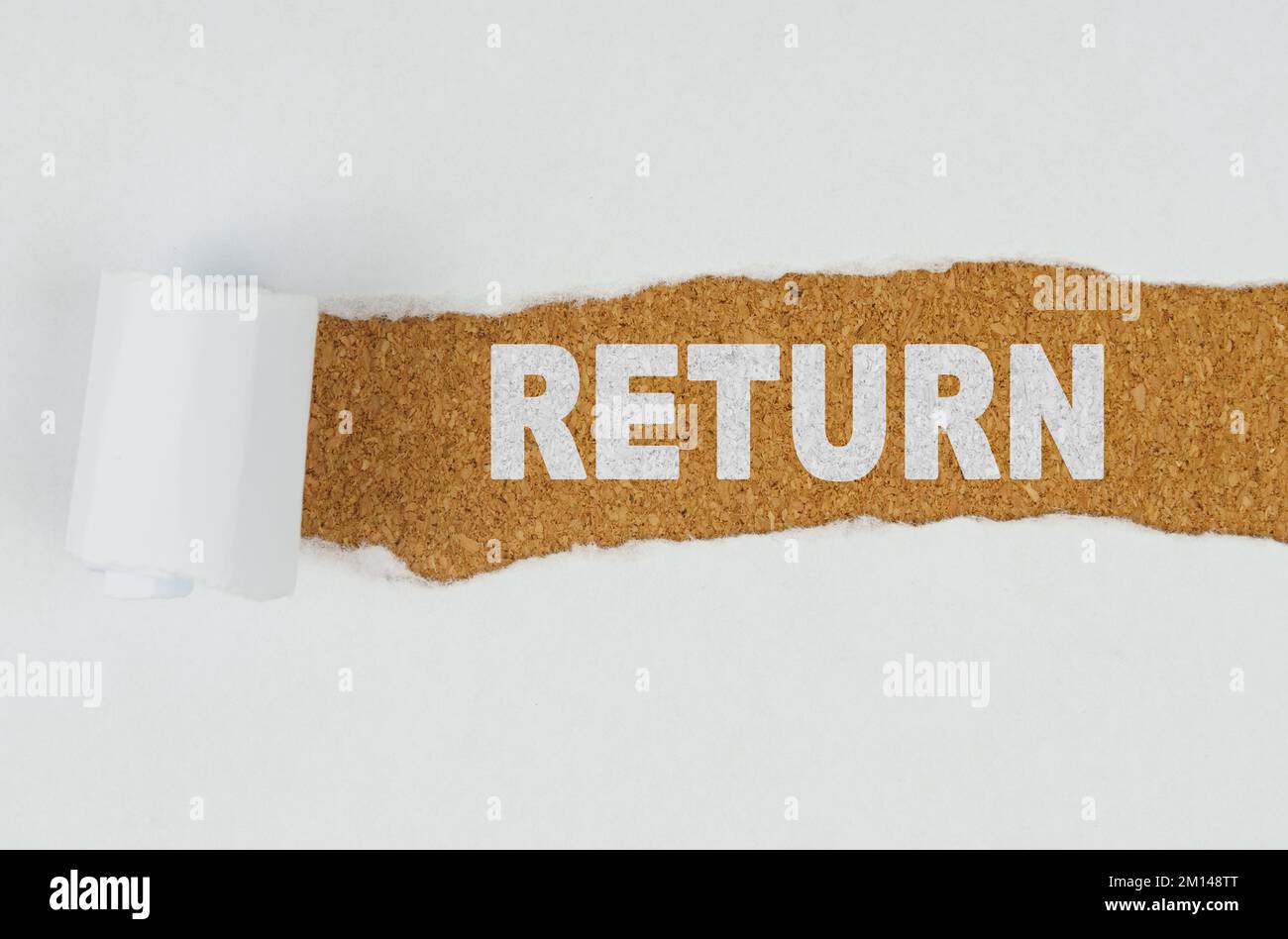 Affari e finanza. Dietro carta bianca strappata su uno sfondo di legno il testo - RITORNO Foto Stock