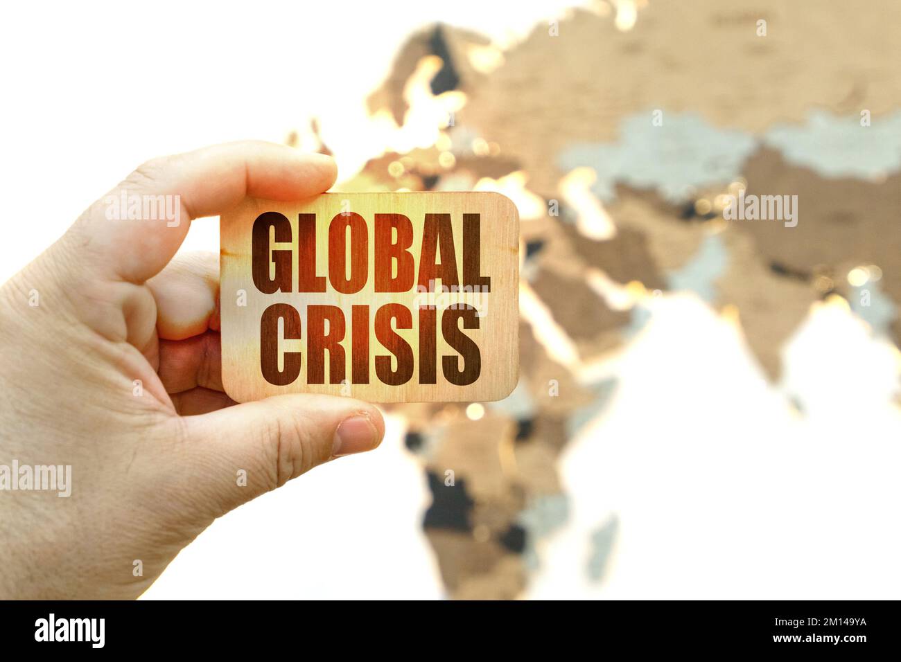 Concetto aziendale. Sullo sfondo della mappa mondiale, un uomo ha un segno con l'iscrizione Global Crisis Foto Stock