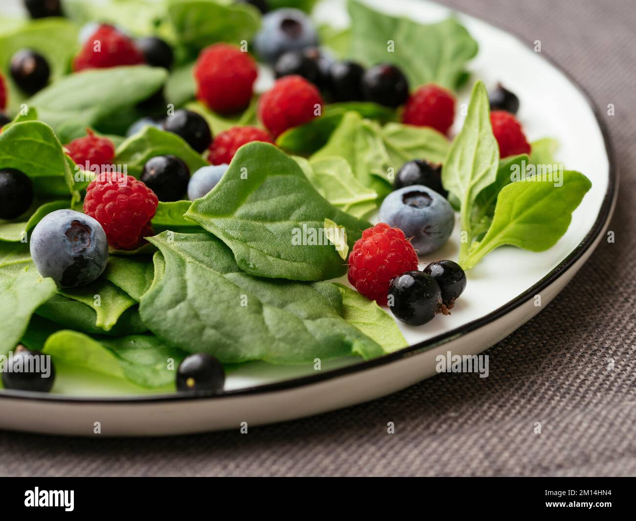 Insalata sana con spinaci freschi della Nuova Zelanda, mirtilli, lamponi e ribes nero Foto Stock