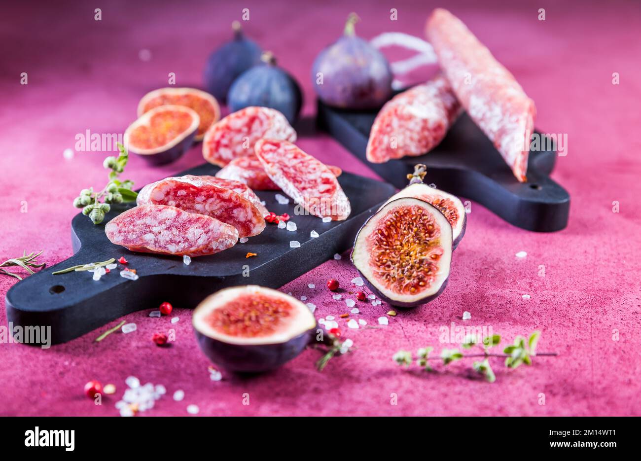 Salame fuet spagnolo con fichi freschi - salumi stagionati e naturali fermentati Foto Stock